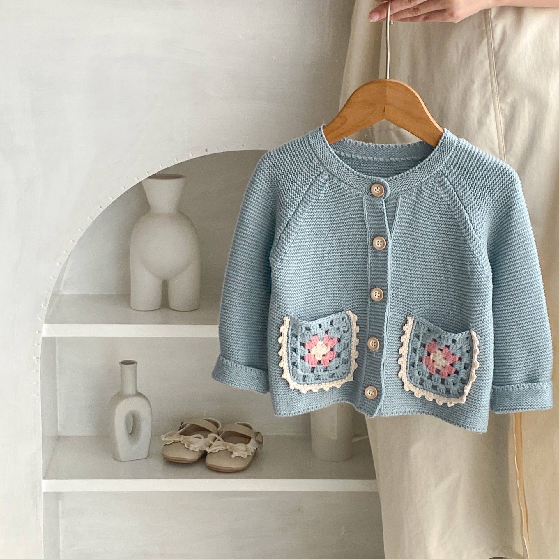 Petal Acorn Cardigan on wooden hanger